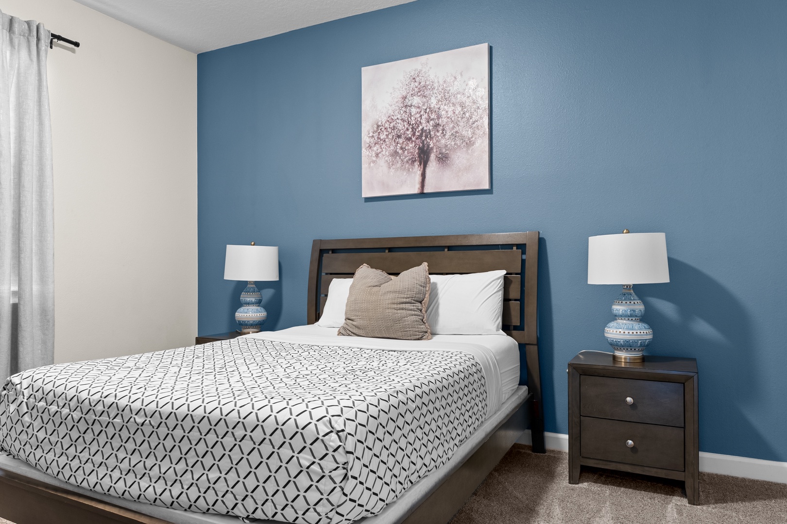 Sink into this serene bedroom where calming blue walls and soft linens create your perfect retreat after exploring the area.