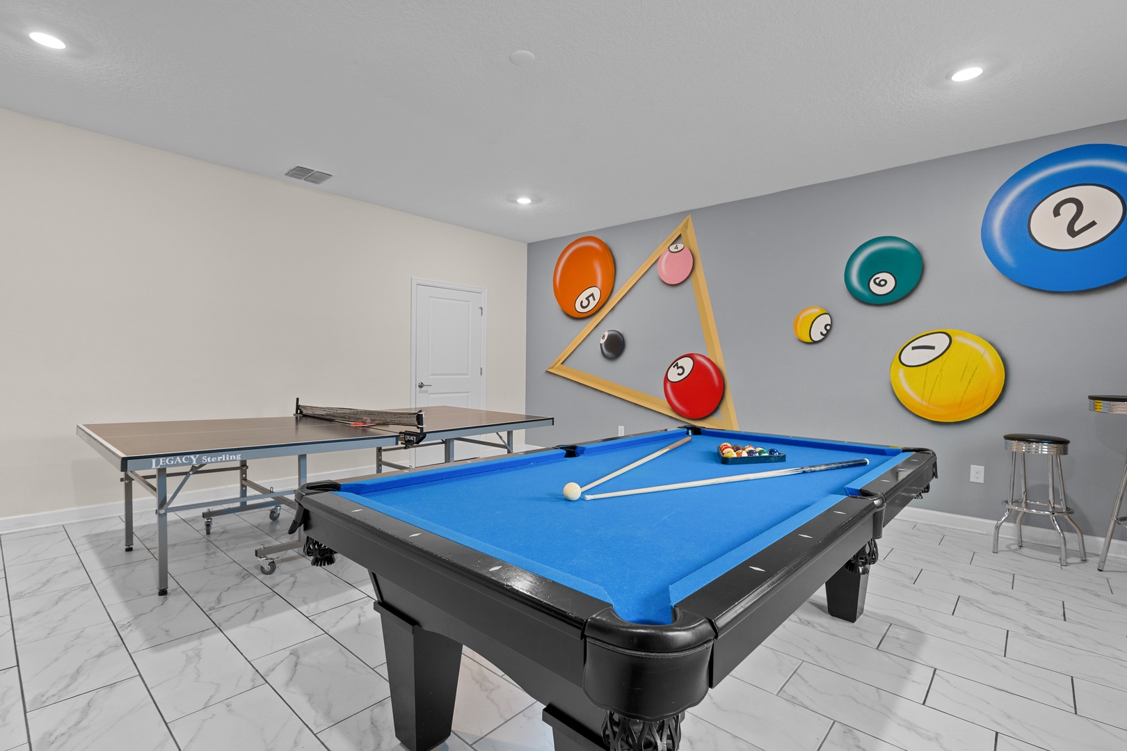 Challenge friends to pool and ping pong in your private game room, complete with vibrant billiard-themed wall art for the perfect competitive atmosphere.