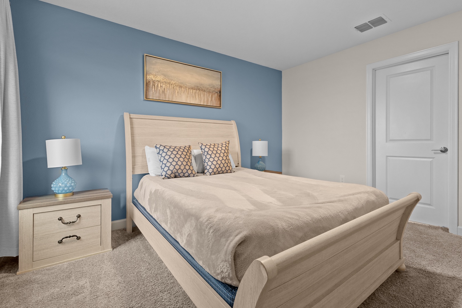 Drift into peaceful sleep in your serene bedroom, where calming blue hues and coastal artwork create the perfect retreat.