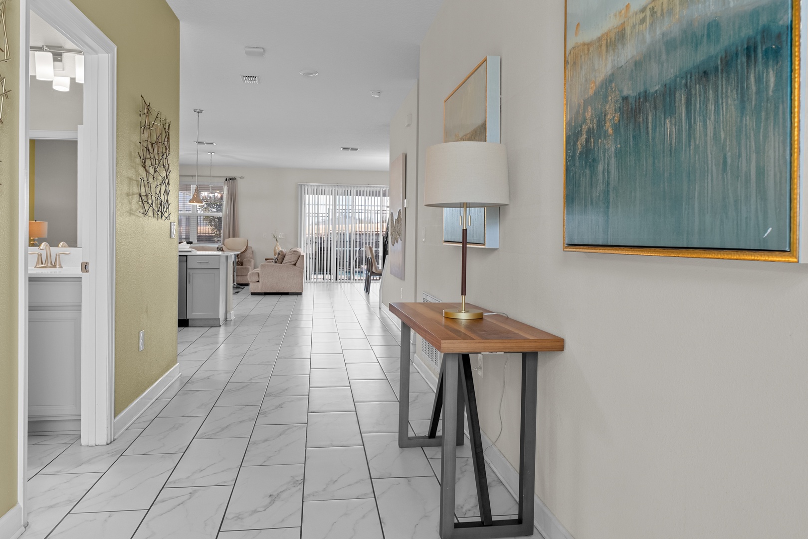 Step into your bright, modern hallway where marble floors lead you through this thoughtfully designed space toward the welcoming living area.