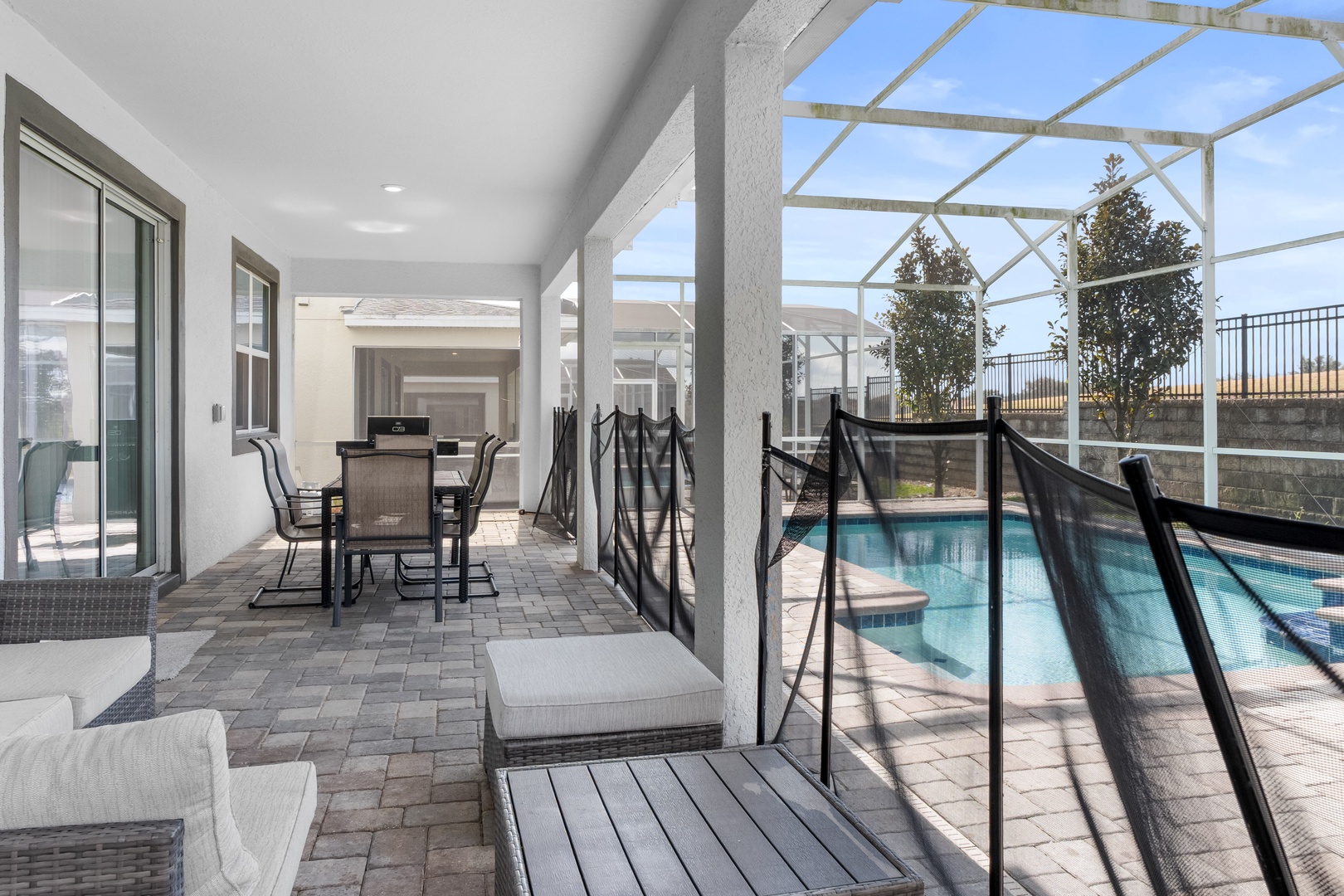 Relax in your screened-in patio with pool views, outdoor dining, and comfortable seating—perfect for unwinding after sunny Florida days.