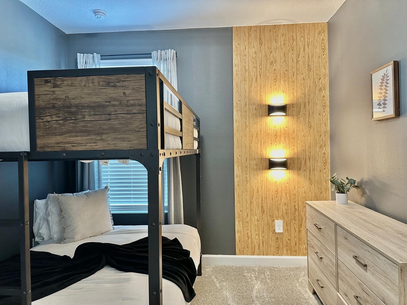 Sleep soundly in your modern bunk room with elegant wood accents and warm ambient lighting creating the perfect restful retreat.