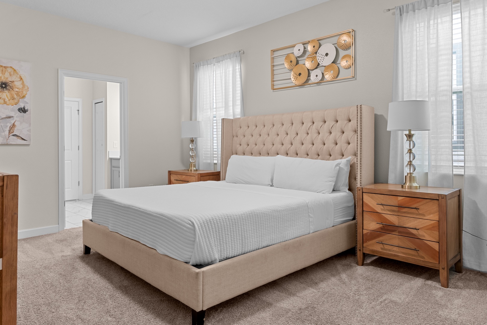 Sink into the plush tufted headboard and crisp linens of your serene bedroom retreat, where warm wood accents create a cozy atmosphere.