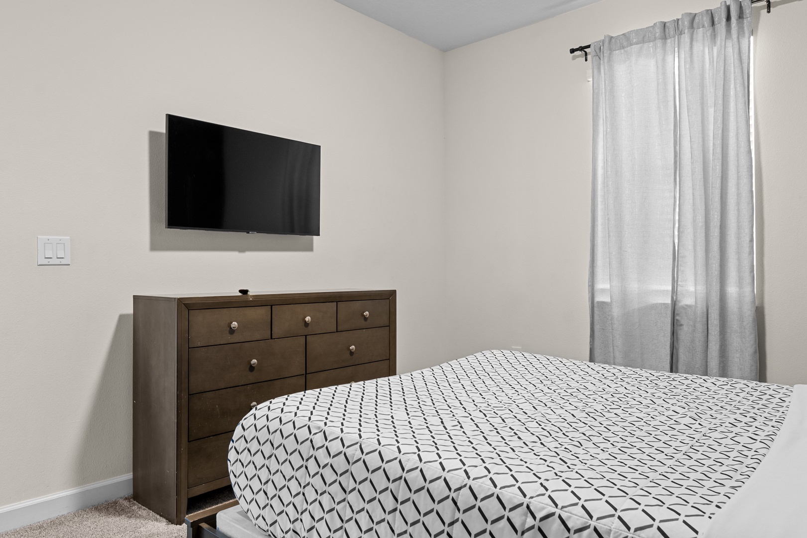 Unwind in your peaceful bedroom with a comfy bed, wall-mounted TV for entertainment, and storage dresser for your belongings.