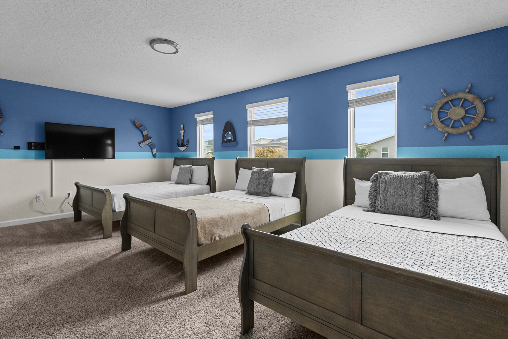 Drift off to sleep in this charming nautical bedroom with three cozy beds and ocean-themed decor that makes you feel seaside.