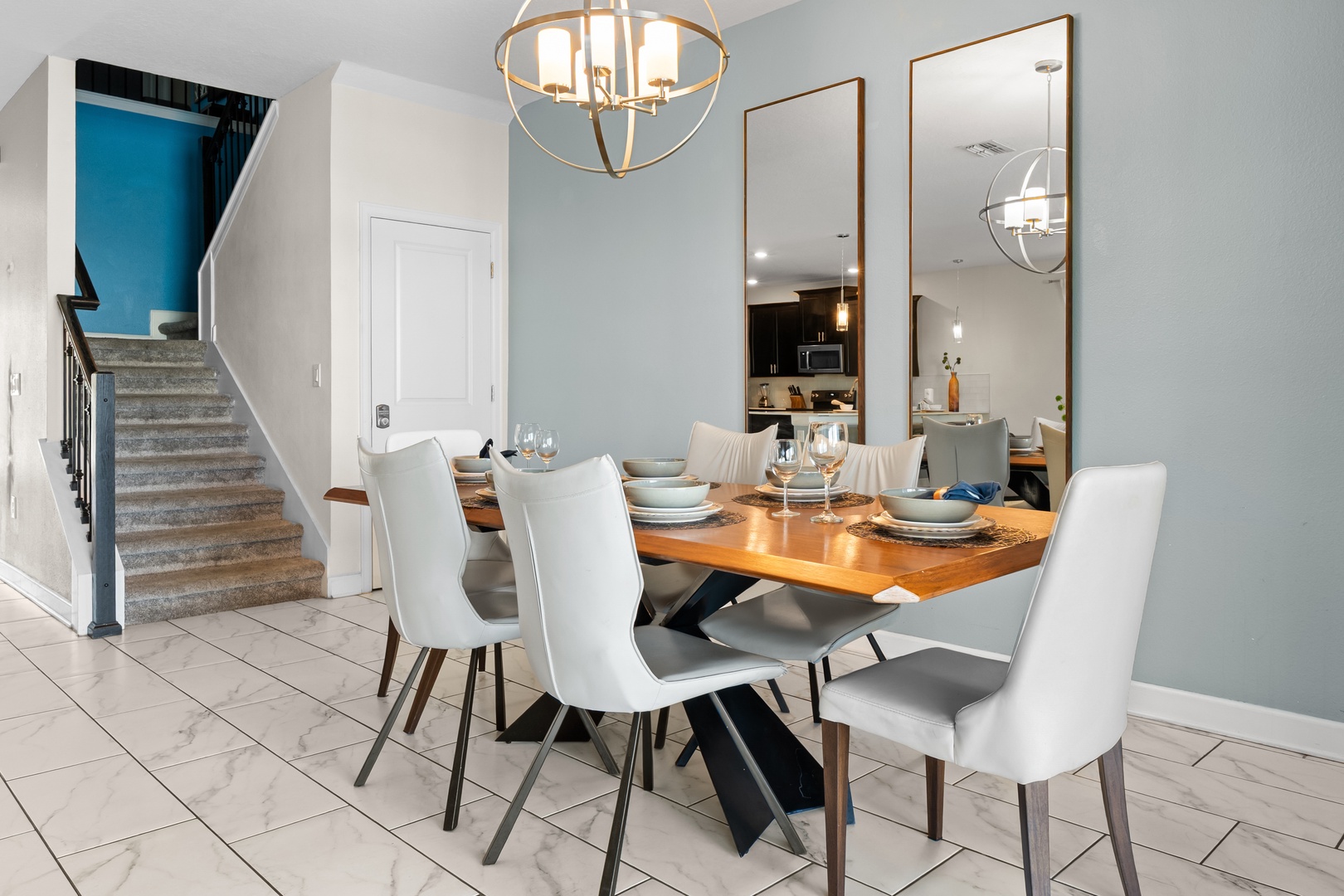Gather around your elegant dining table where modern design meets comfort. The warm chandelier creates perfect ambiance for memorable meals together.