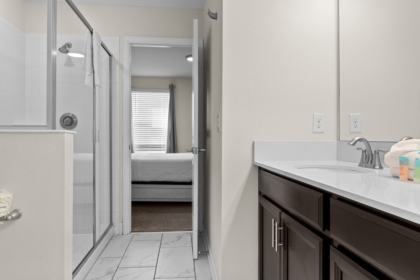 Step into your spacious bathroom with modern finishes, complete with a glass shower and convenient access to your cozy bedroom.