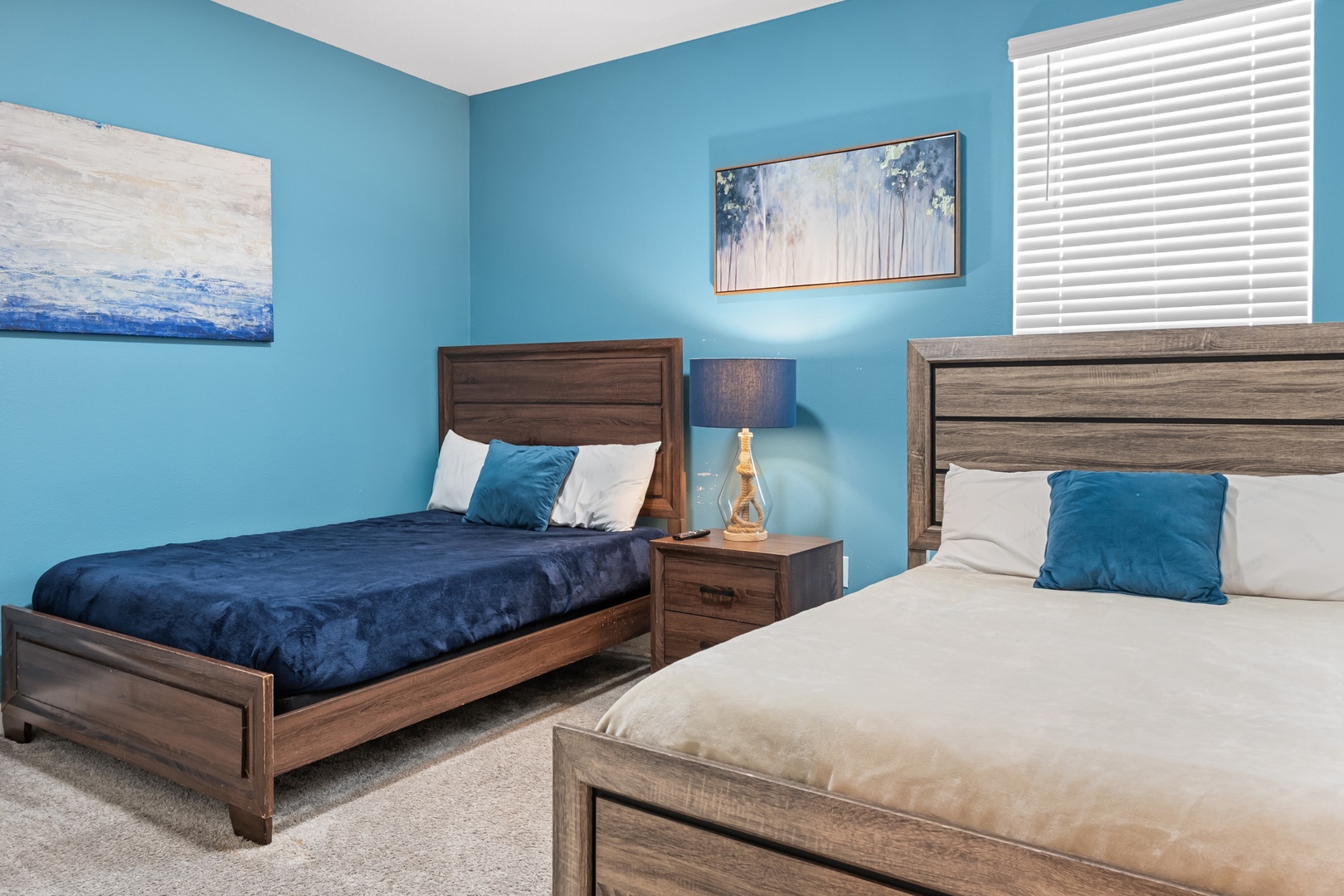 Drift off in your peaceful twin bedroom featuring coastal-inspired artwork and plush bedding in calming ocean blues.