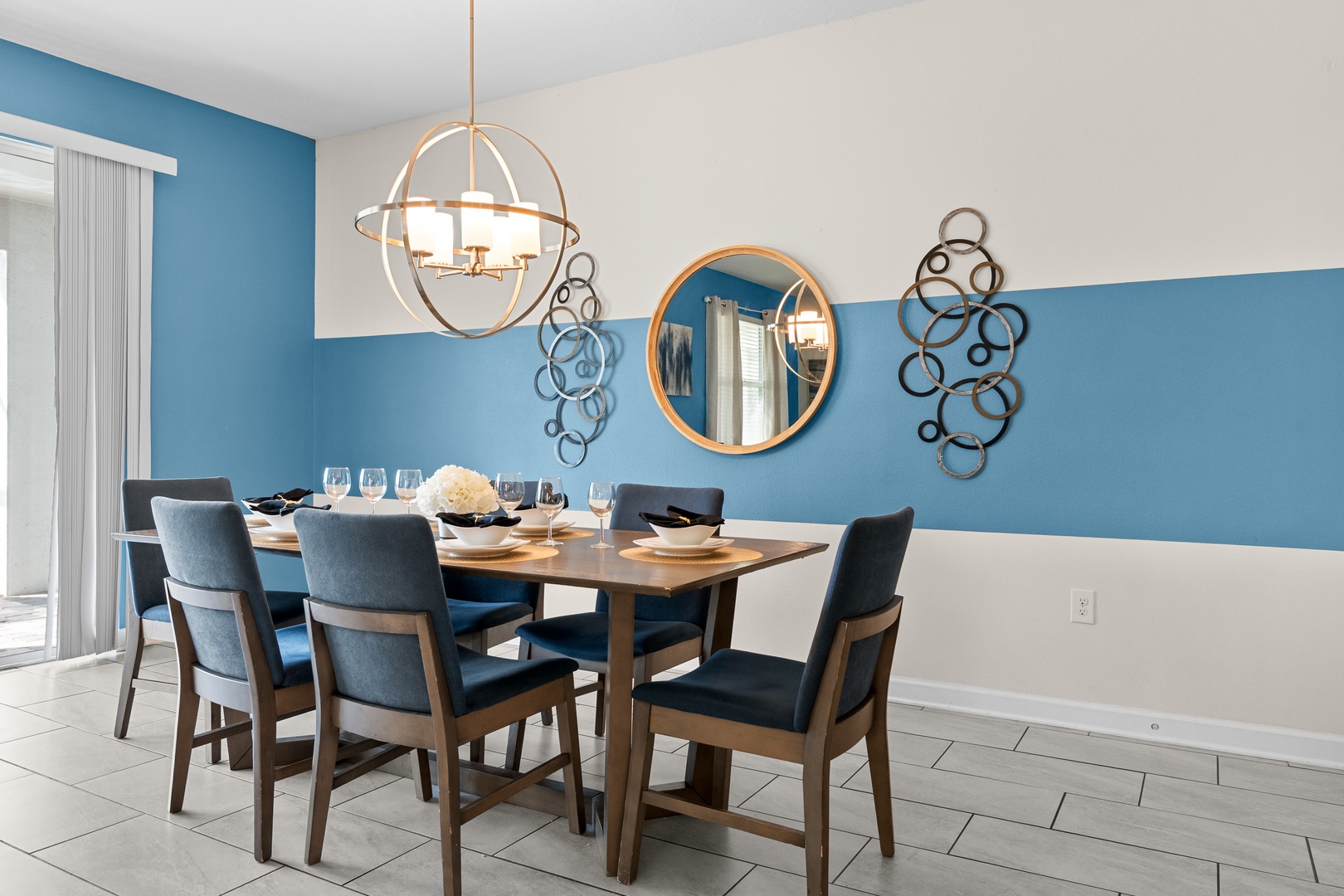 Gather around your stylish dining table for memorable meals in this bright, modern space with contemporary blue accents and elegant lighting.
