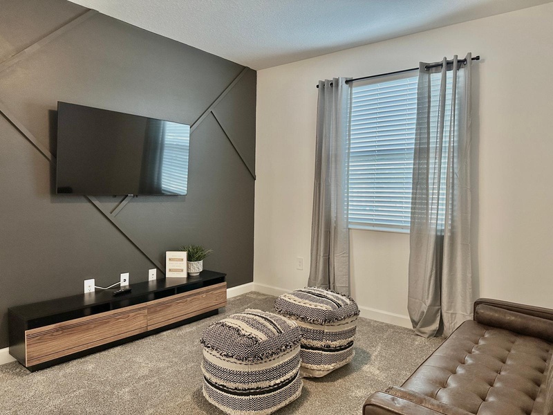 Unwind in your stylish living space with modern entertainment center and cozy seating for relaxing evenings.