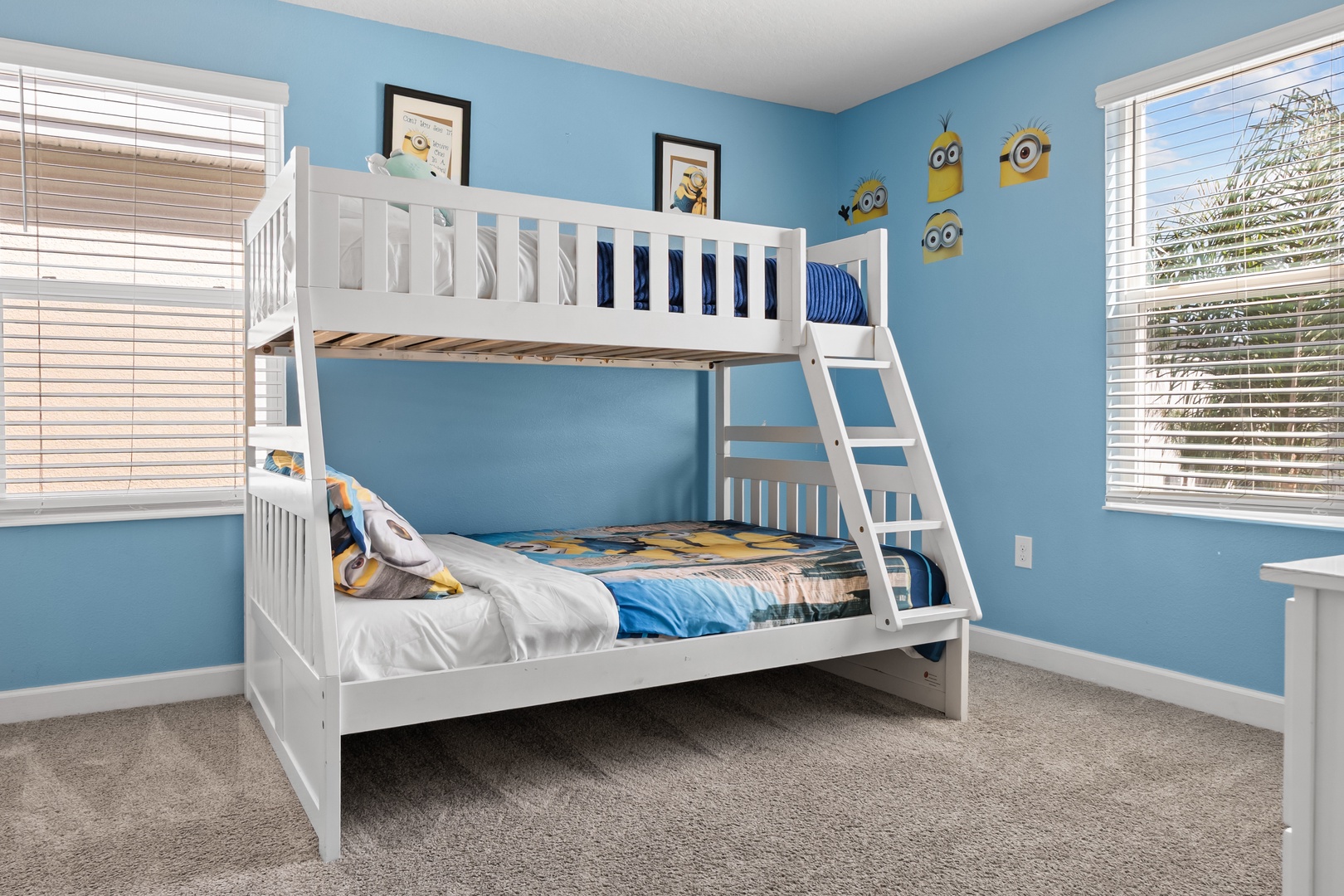 Your kids will love this cheerful Minions-themed bunk room with its playful blue walls and cozy twin-over-full setup.