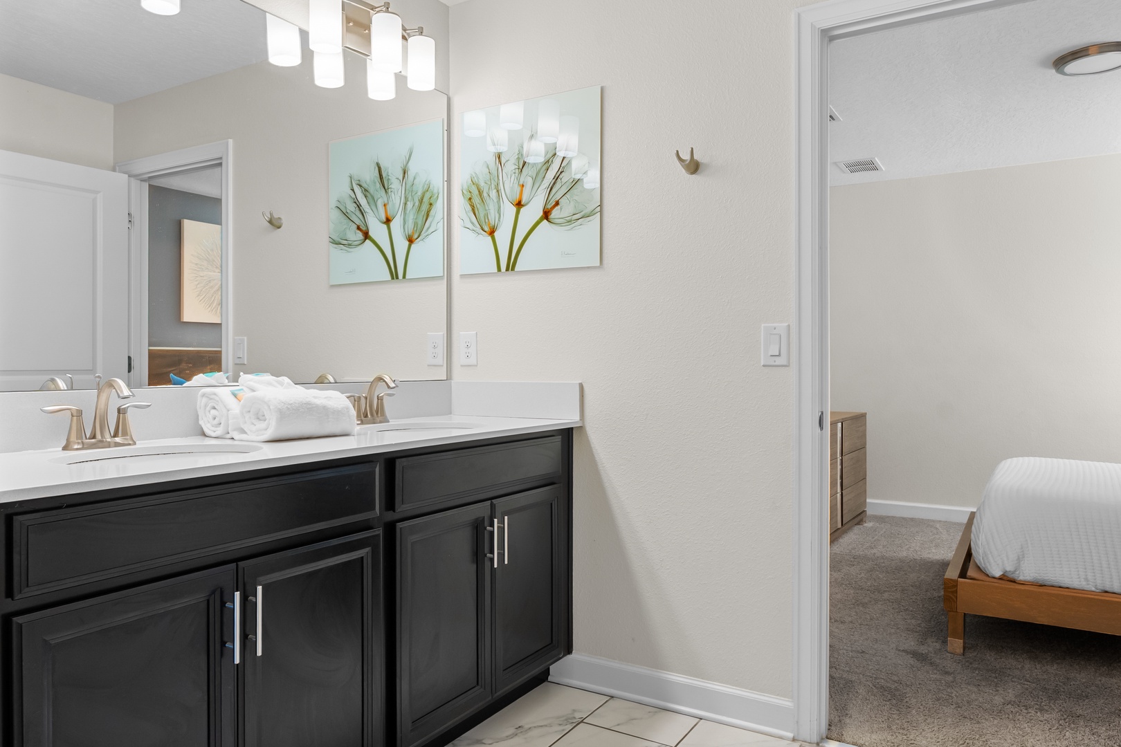 Your stylish bathroom features elegant vanity lighting, fresh towels, and beautiful botanical artwork to start your day refreshed.
