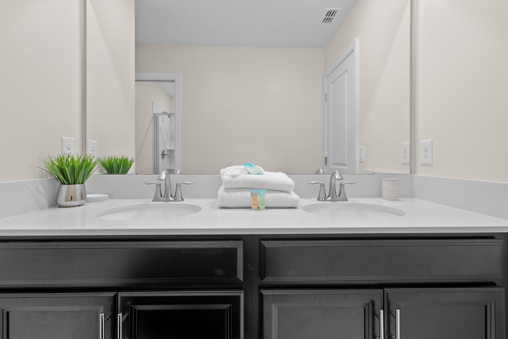 Your spa-like bathroom features dual sinks with elegant marble countertops, fluffy towels, and thoughtful touches that make your morning routine feel luxurious.