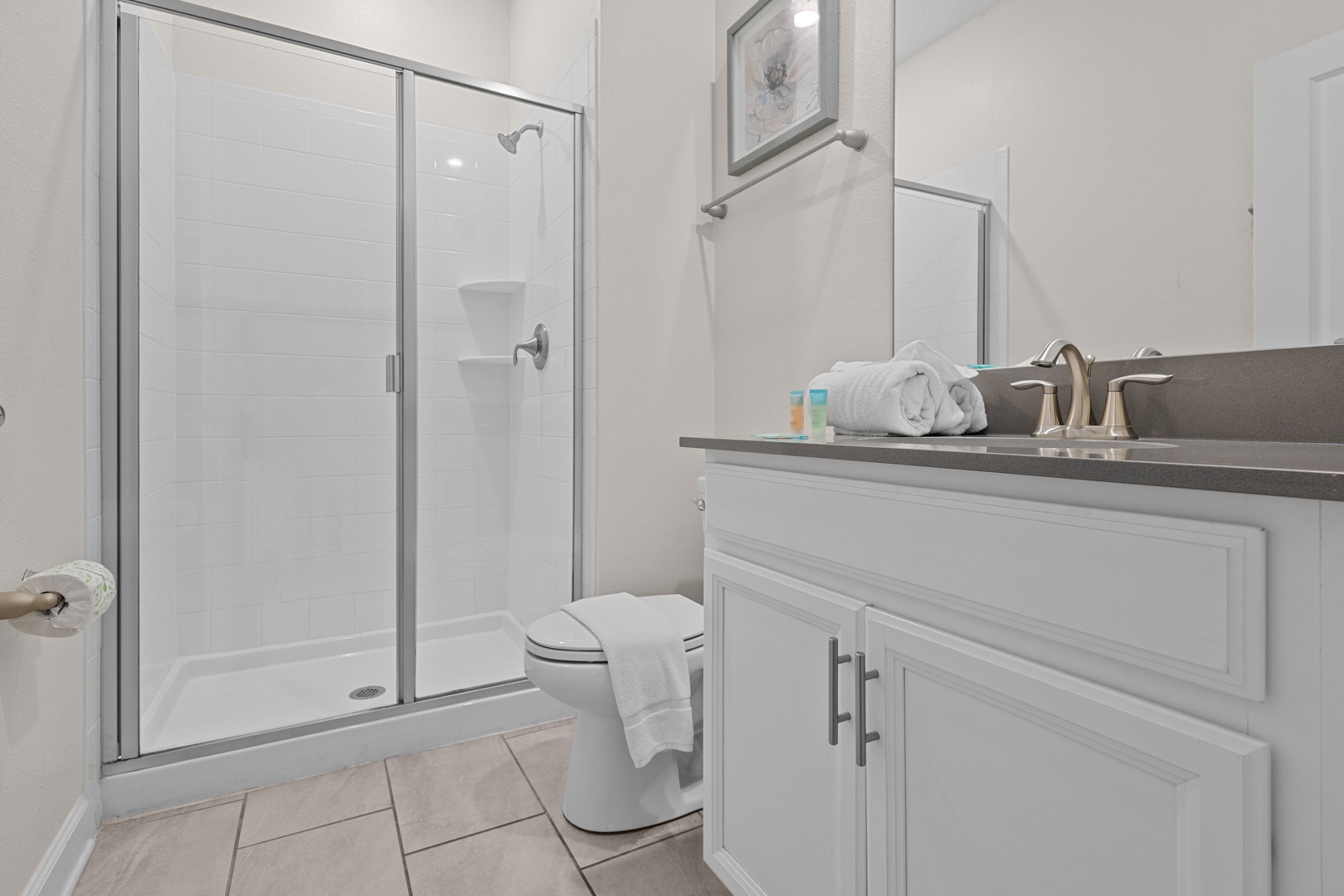 Refresh in your pristine private bathroom with modern shower, plush towels, and elegant granite countertops.