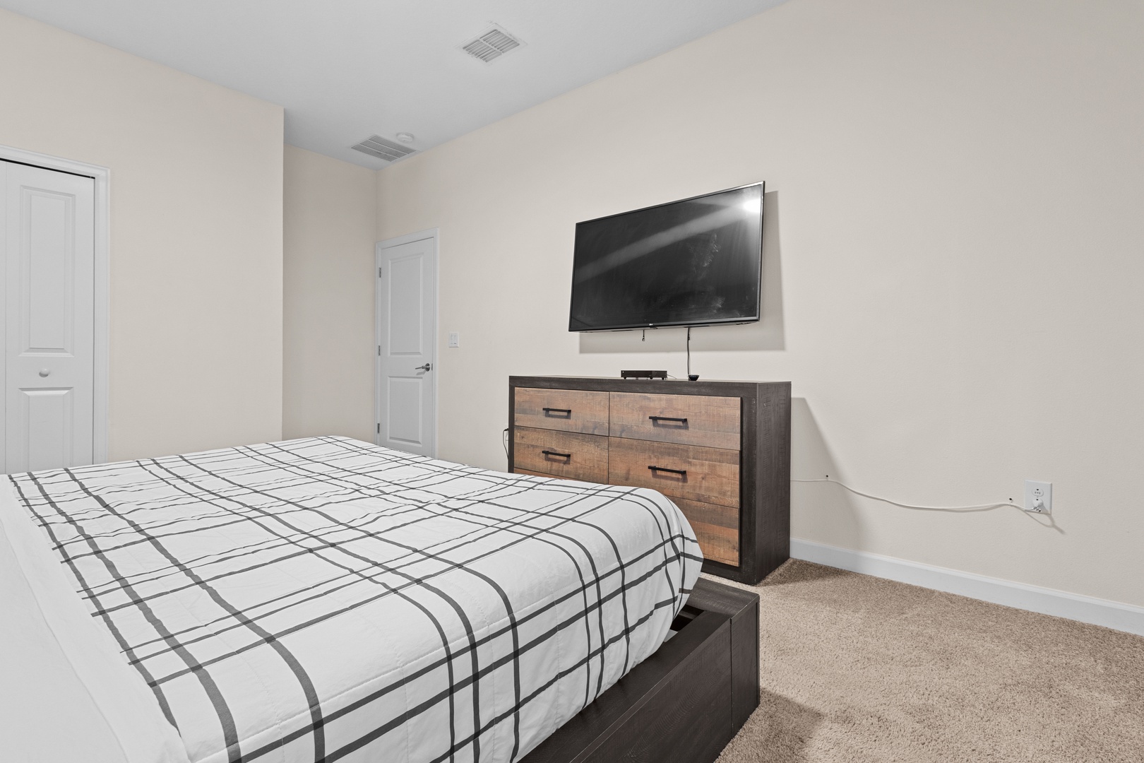 Unwind in your comfortable bedroom featuring modern furnishings and wall-mounted TV for cozy evenings.