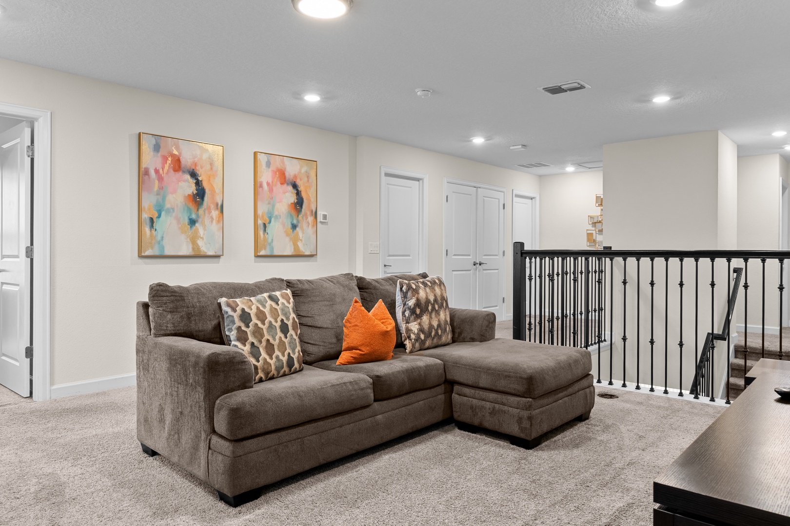 Sink into this cozy sectional sofa where you can unwind with colorful artwork brightening your upstairs retreat space.