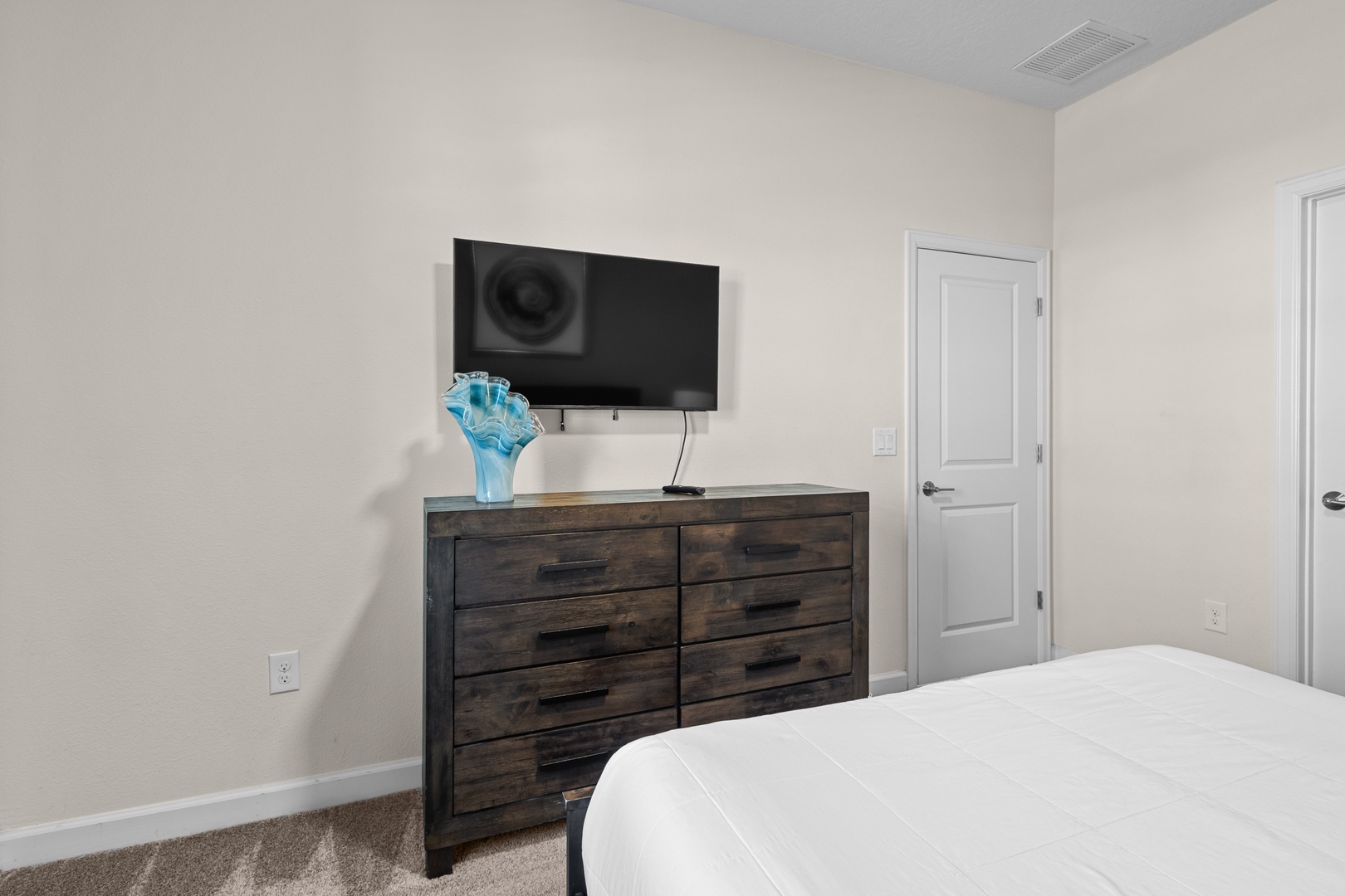 Your bedroom features a wall-mounted TV and rustic wooden dresser, creating a cozy retreat for restful nights.