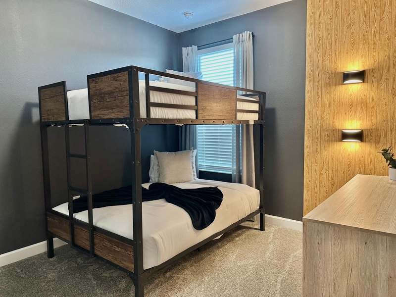 Sleep soundly in this stylish bunk room with warm wood accents and gentle ambient lighting creating your perfect retreat.