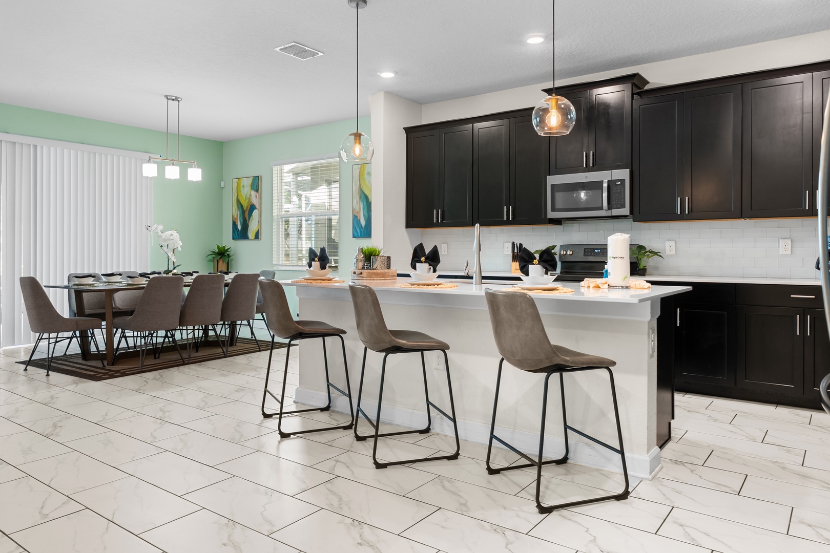 Your spacious kitchen features sleek dark cabinets, white quartz countertops, and a breakfast island where you can enjoy morning coffee together.