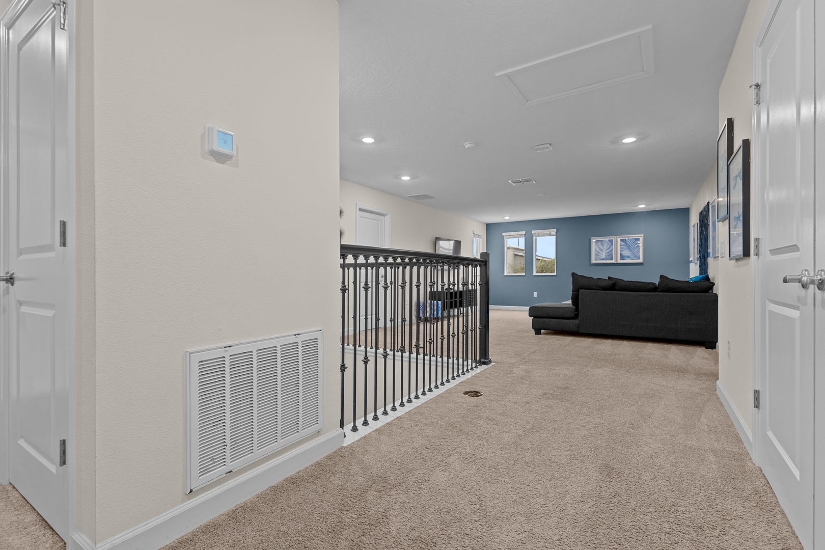 Relax in your spacious upstairs loft with cozy seating and peaceful blue accent wall—perfect for unwinding after exploring.