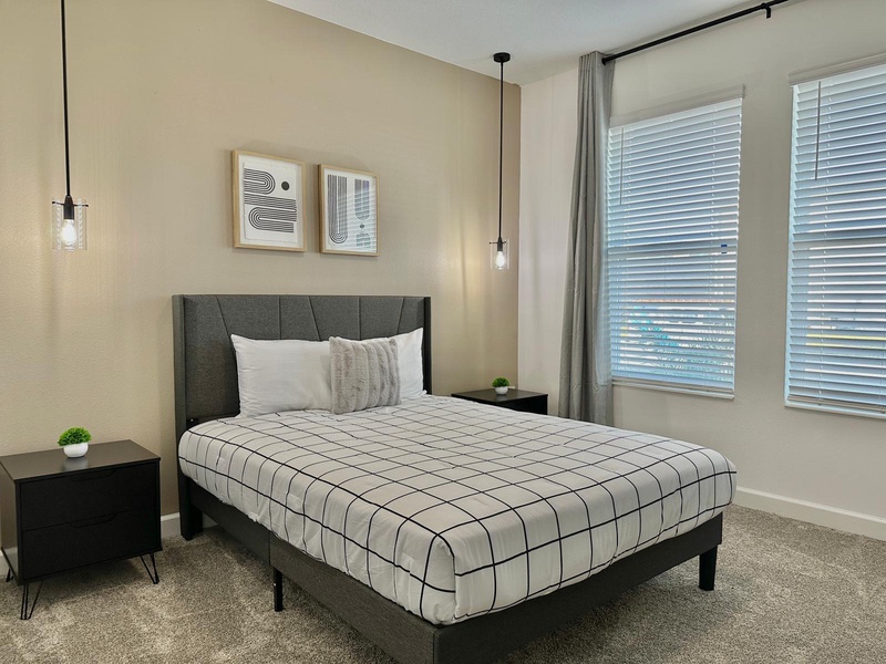 Sink into your comfortable queen bed with crisp linens and modern decor, where stylish pendant lights create perfect reading ambiance.