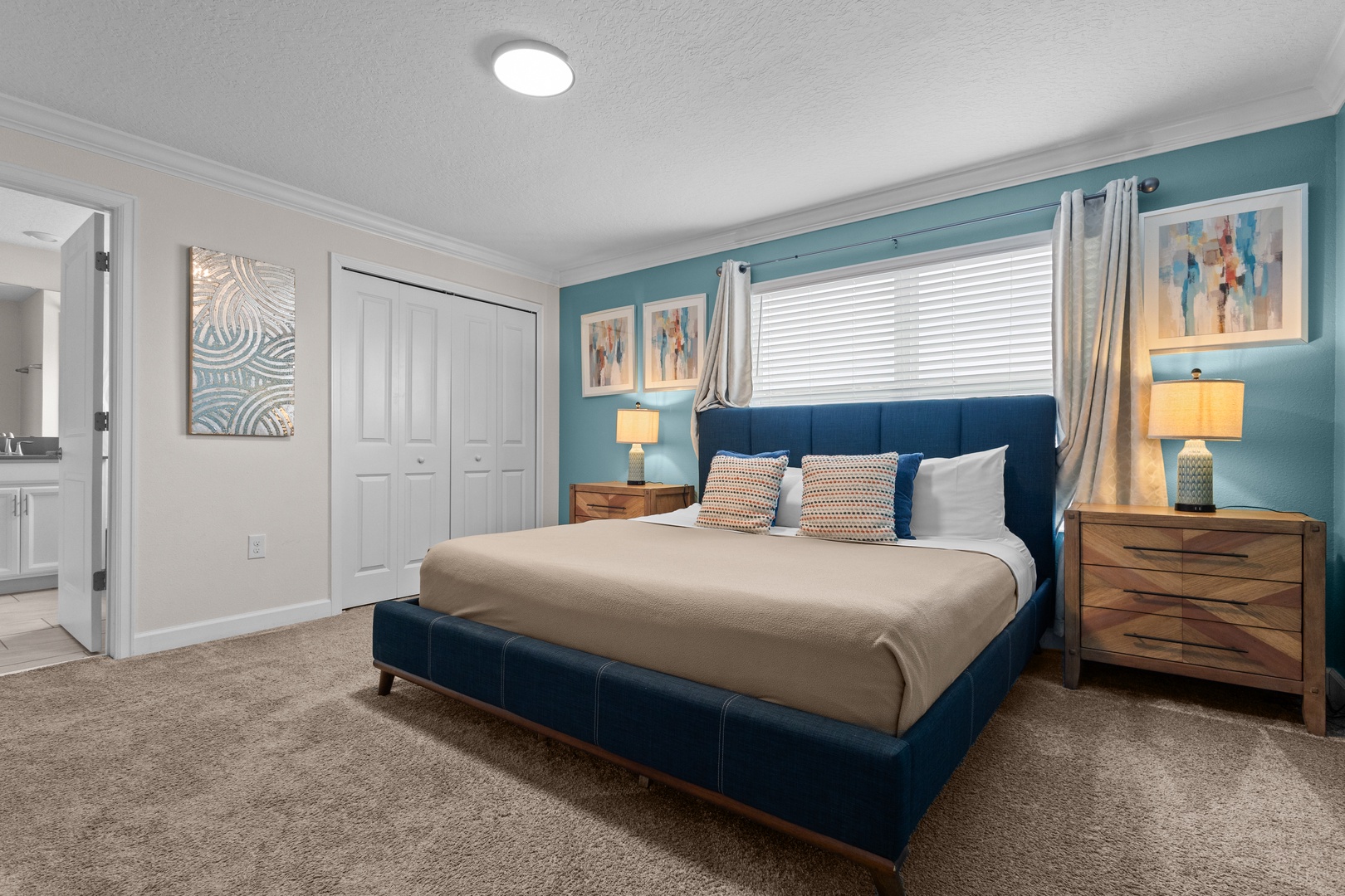 Sink into this plush navy bed surrounded by calming teal walls and warm wood furnishings for your perfect night's rest.