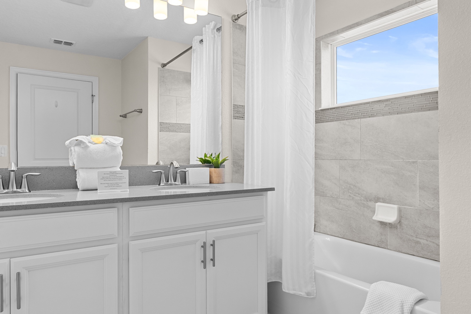 Refresh in your bright, modern bathroom with elegant marble tiles and crisp white linens awaiting your arrival.
