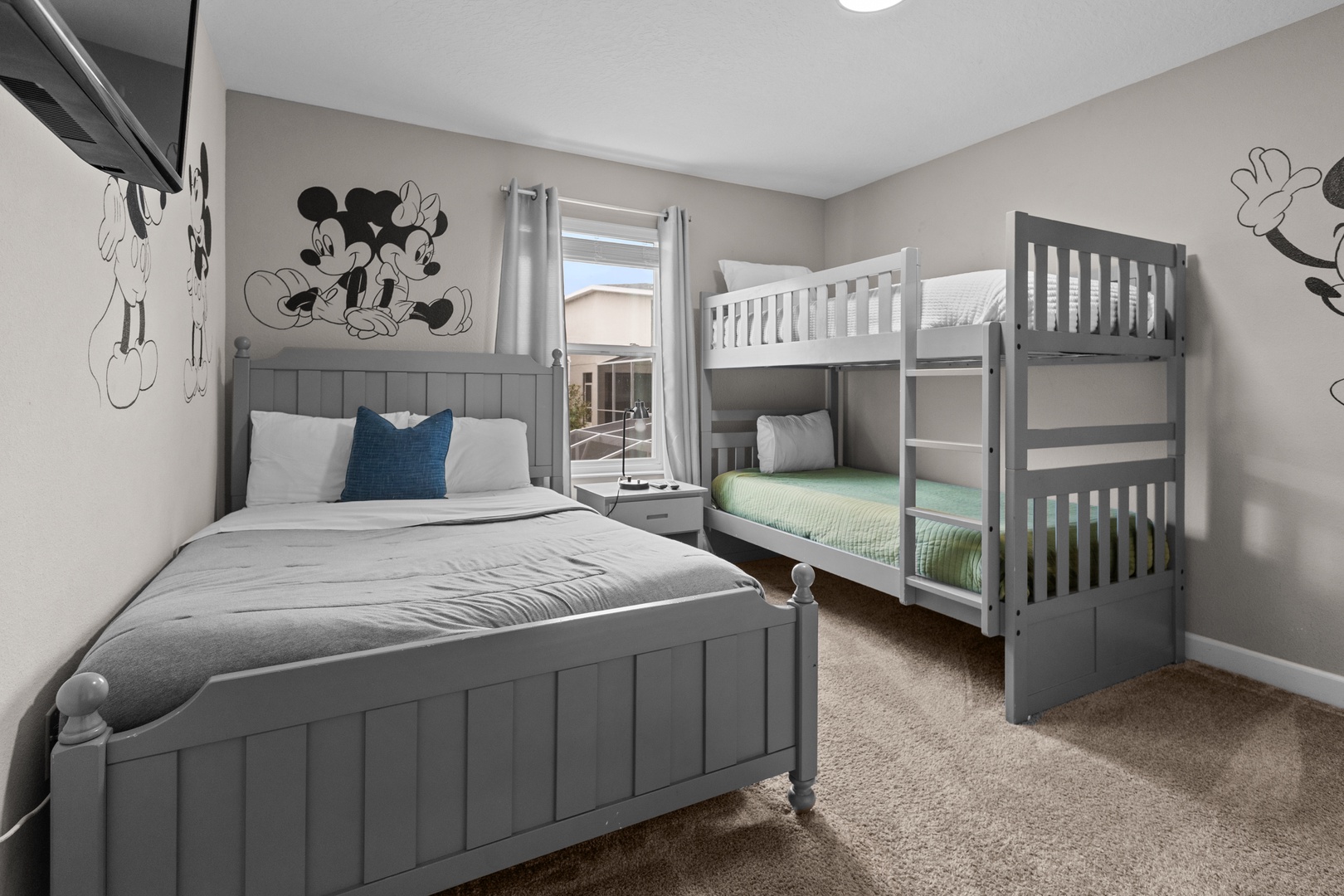 Your kids will love this magical Disney-themed bedroom with cozy beds and playful Mickey Mouse decals creating the perfect family retreat.