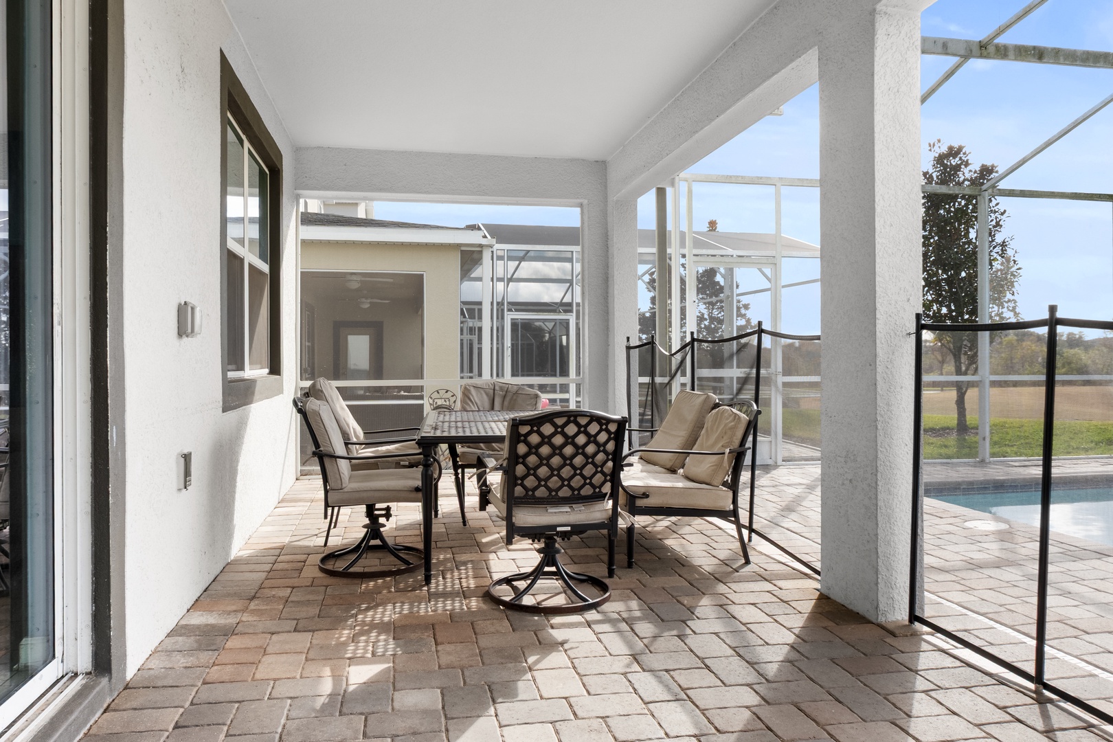 Your screened patio offers comfortable outdoor dining with pool views, perfect for morning coffee or evening relaxation.