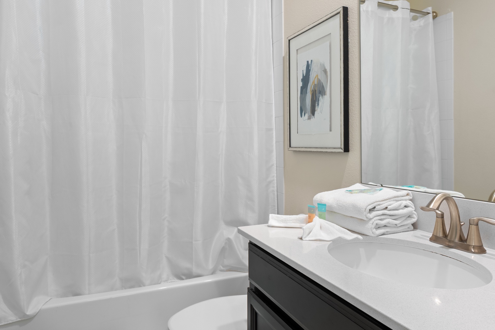 Unwind in your private bathroom with fresh towels, modern fixtures, and a relaxing tub for soaking after busy days exploring.