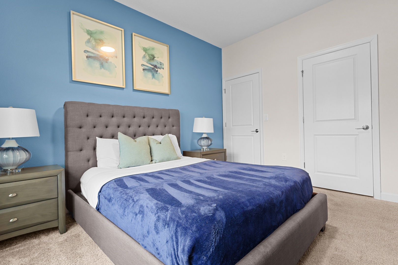 Drift off in your serene bedroom featuring ocean-inspired blues, plush tufted headboard, and soft lighting that creates the perfect peaceful retreat.
