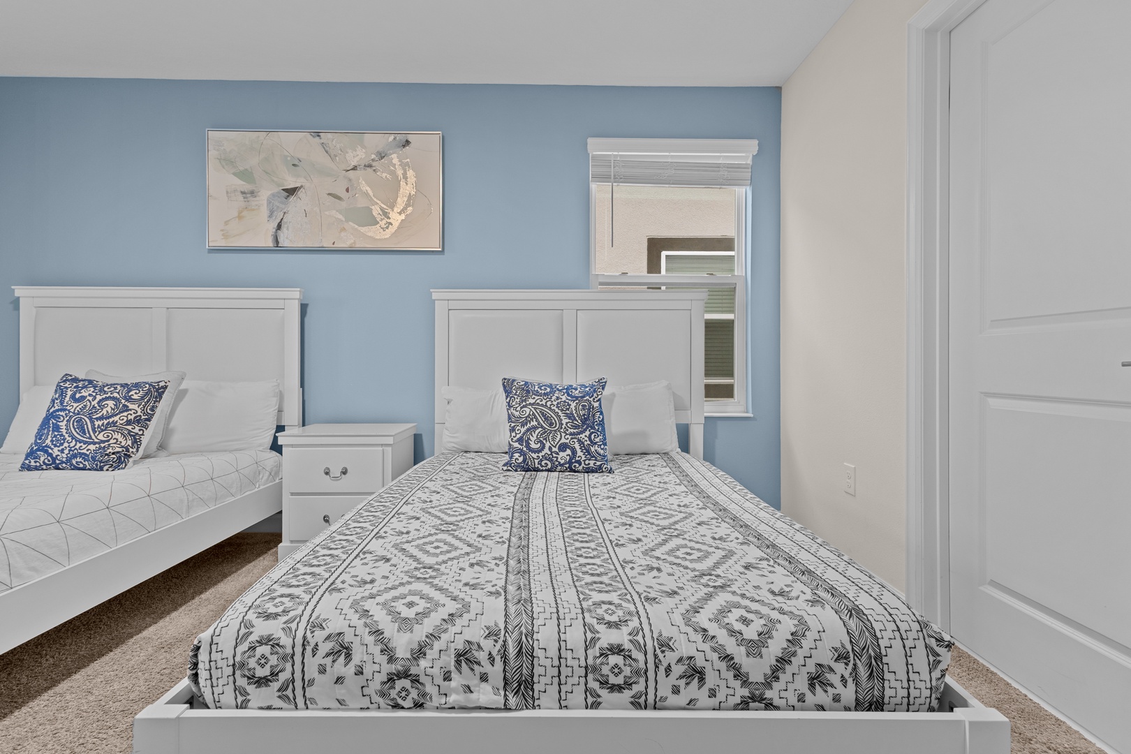 Sink into comfort in this peaceful twin bedroom, where soothing blue walls and crisp white furnishings create your perfect retreat.