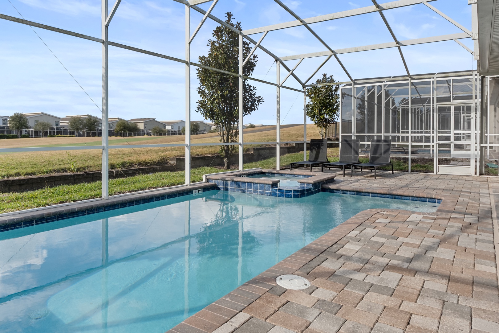 Your private screened pool and spa await, with crystal-clear waters reflecting the Florida sky and peaceful views beyond.