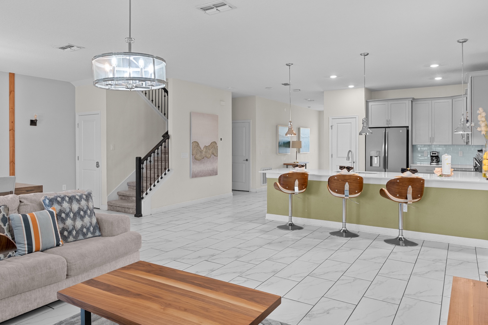 Your modern open-concept living space flows seamlessly from cozy seating to a fully equipped kitchen with sleek island dining for three.