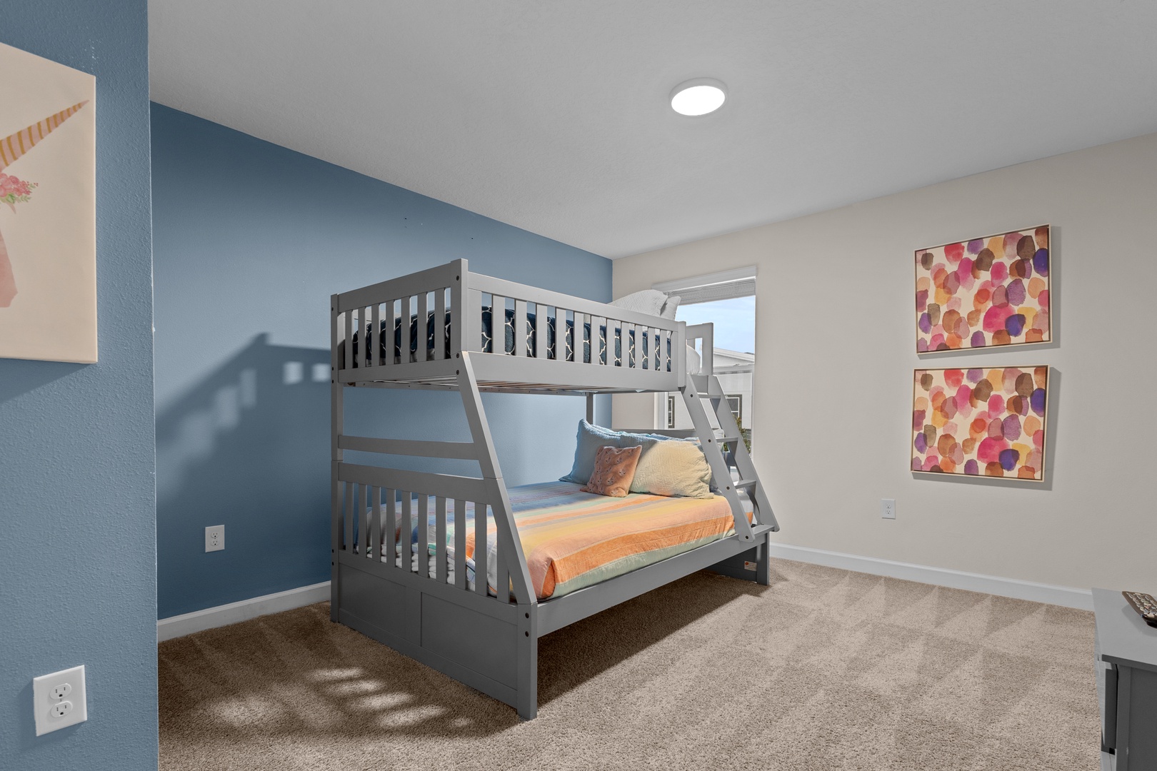Rest comfortably in your cheerful bunk room with soft carpeting, playful artwork, and cozy bedding.