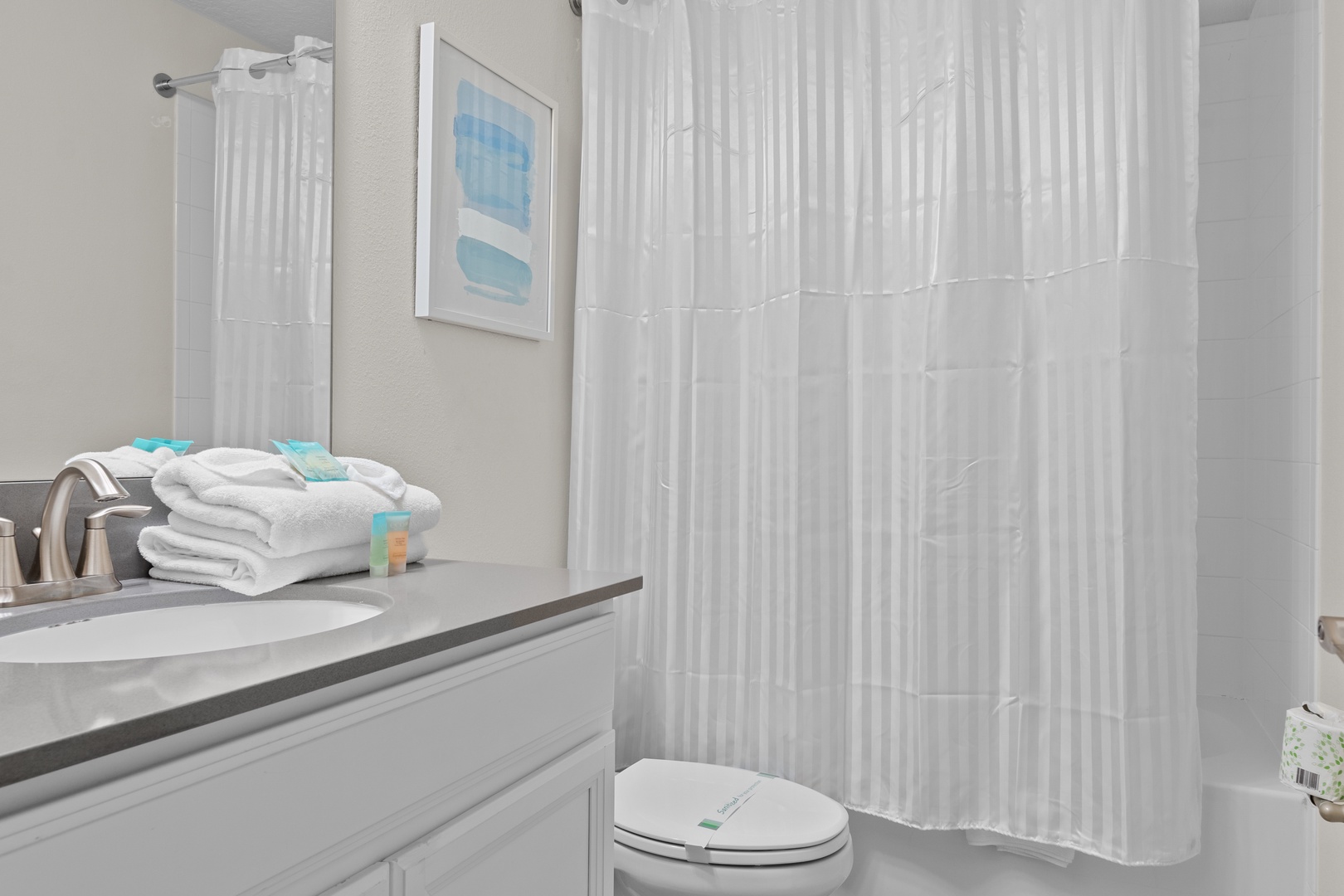 Step into your private sanctuary with a refreshing shower, fluffy towels waiting, and coastal artwork that brings seaside serenity to your morning routine.