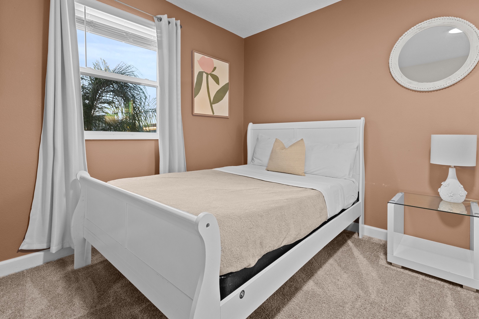 Sink into this cozy bedroom's plush bedding after watching tropical palm trees sway outside your window. The warm tones create a peaceful retreat.