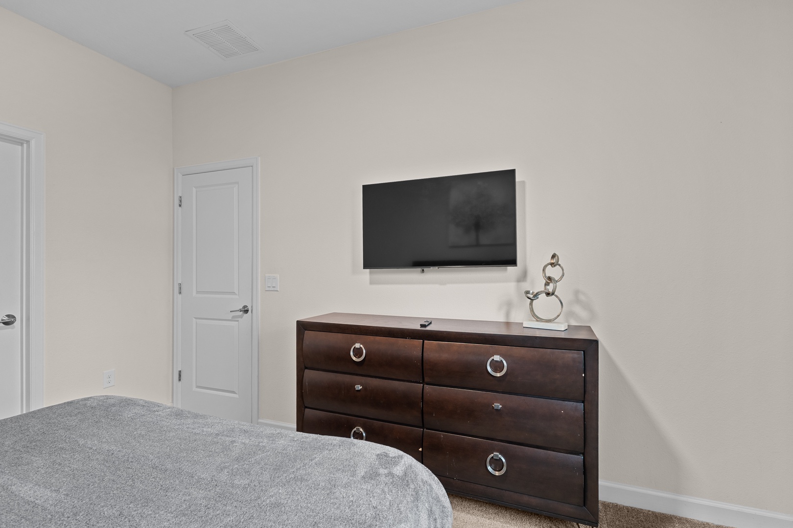 Unwind in your peaceful bedroom with a wall-mounted TV for cozy movie nights and elegant furniture for all your belongings.