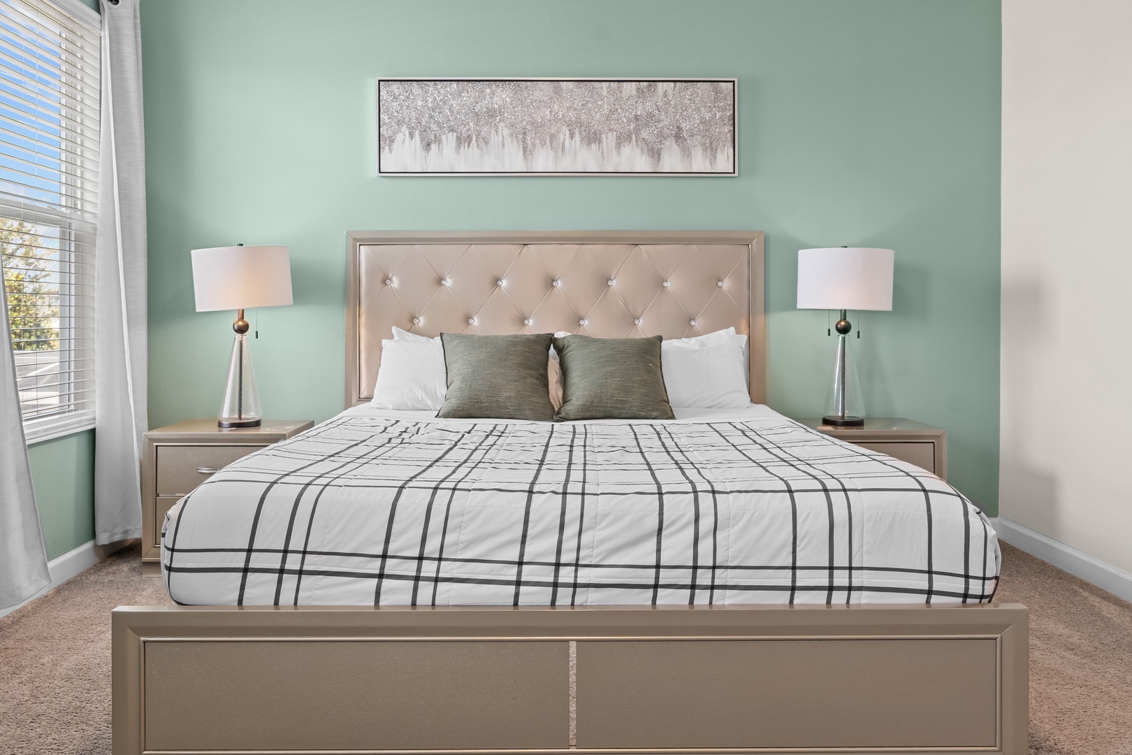 Sink into this elegant king bed with plush pillows and crisp linens. The soothing mint green walls and modern furnishings create your perfect retreat.