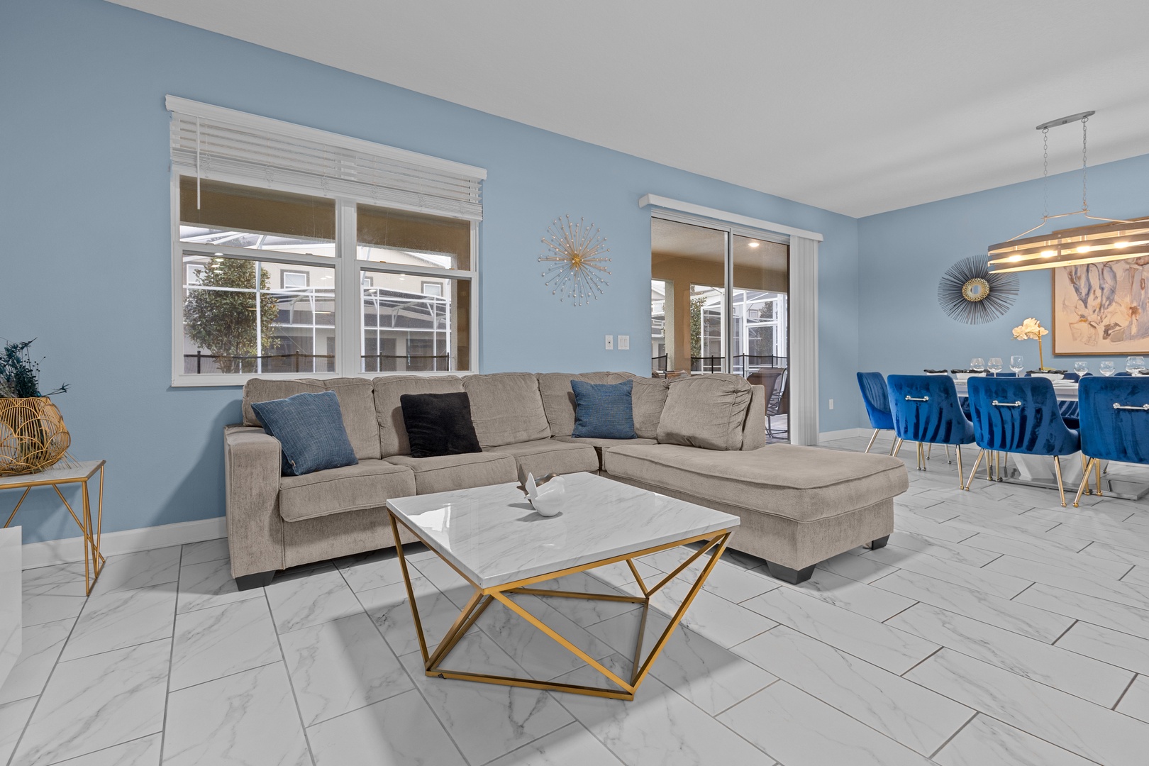 Unwind in your spacious living room with plush sectional seating and vibrant blue accents that create the perfect atmosphere for relaxation.