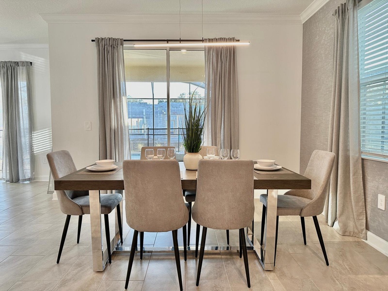 Gather around your elegant dining table for memorable meals, with natural light streaming through floor-to-ceiling windows and stylish modern furnishings creating the perfect atmosphere.