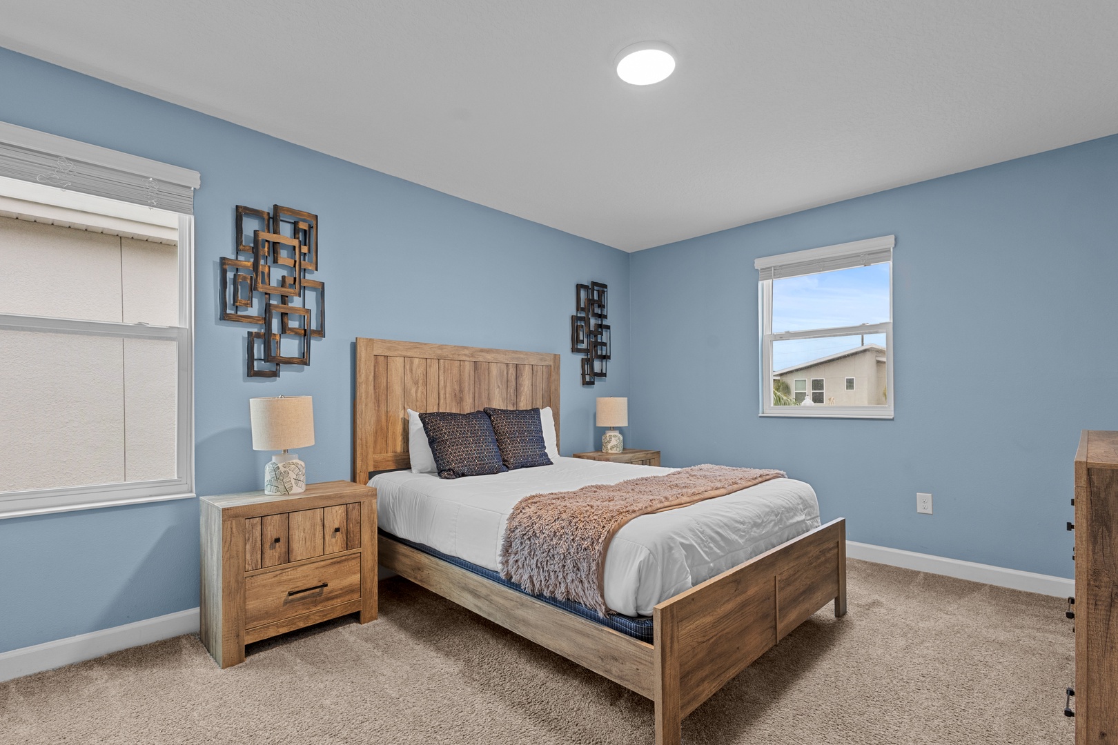 Drift off to sleep in your serene bedroom featuring calming blue walls, rustic wood furnishings, and soft lighting that creates the perfect restful retreat.
