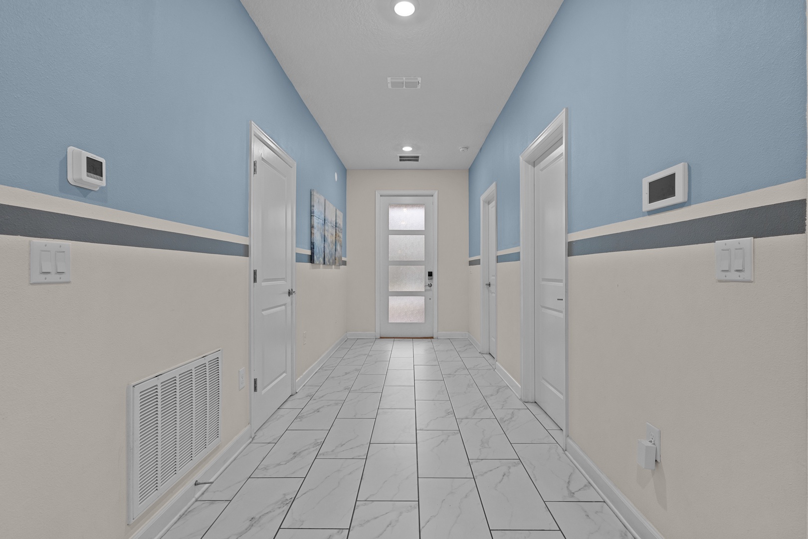 Step into your welcoming hallway with soothing blue and cream tones, marble-look flooring, and individual climate control for your comfort.