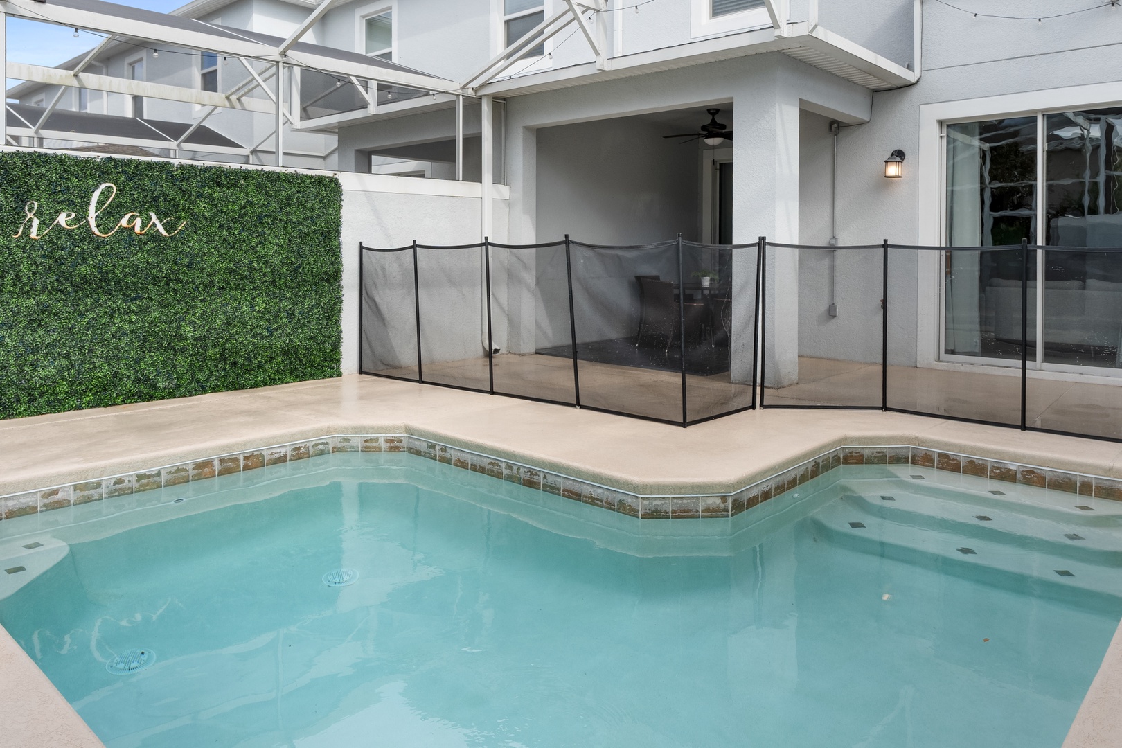 Dive into your private pool oasis, complete with safety fencing and charming 'relax' wall art to set the mood.