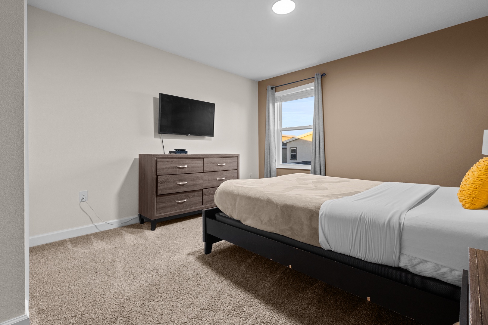 Unwind in your comfortable bedroom with plush bedding, wall-mounted TV, and ample dresser storage for all your belongings.