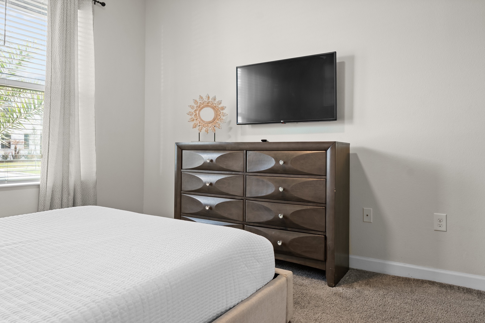 Relax in your comfortable bedroom with modern furnishings, a wall-mounted TV for entertainment, and plenty of storage for your belongings.