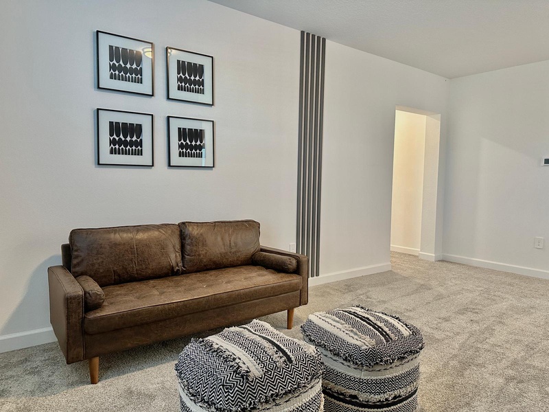 Sink into this cozy leather sofa and unwind in your stylish retreat, where modern art and soft textures create the perfect atmosphere for relaxation.