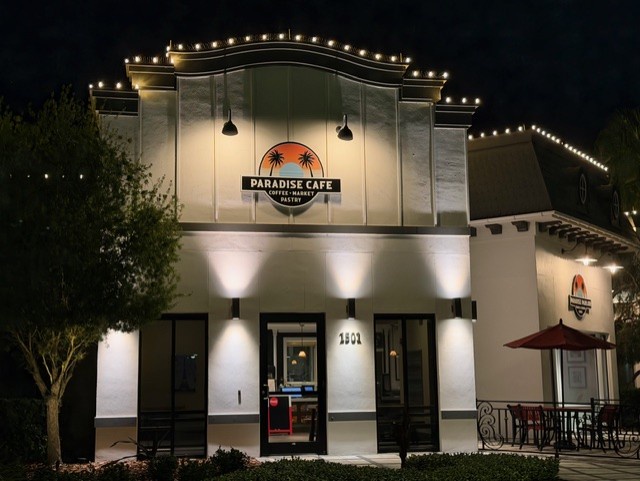 Paradise Cafe's welcoming facade glows with warm lights, creating an inviting atmosphere for evening dining in the neighborhood.
