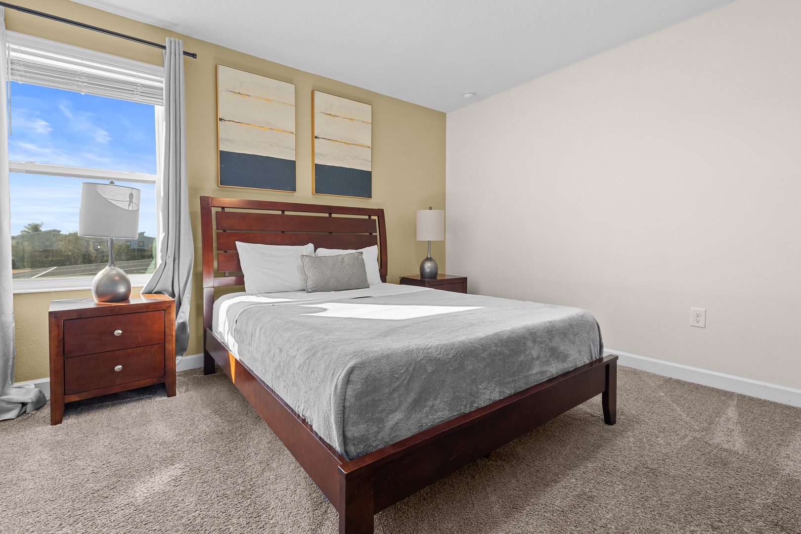 Sink into crisp white linens and soft gray textures in your serene bedroom, where warm wood furnishings and peaceful artwork create the perfect retreat.