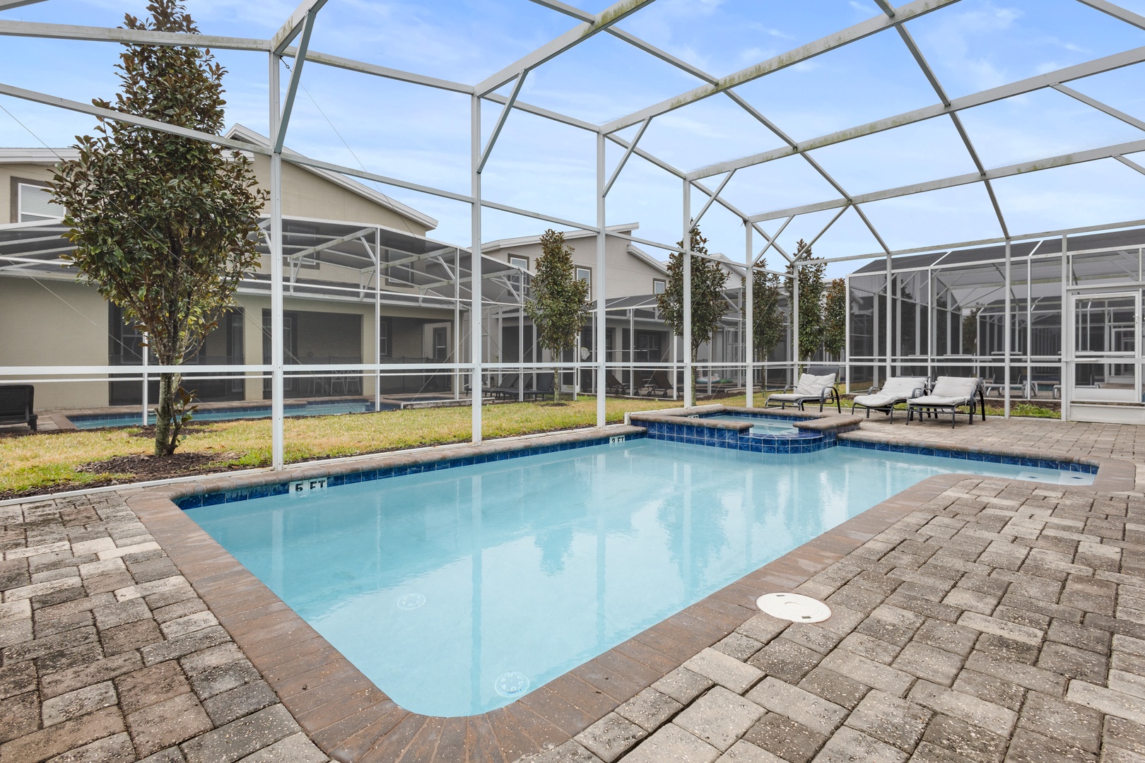 Your private screened pool awaits with sparkling blue water and comfortable loungers, perfect for refreshing swims and sunny relaxation.